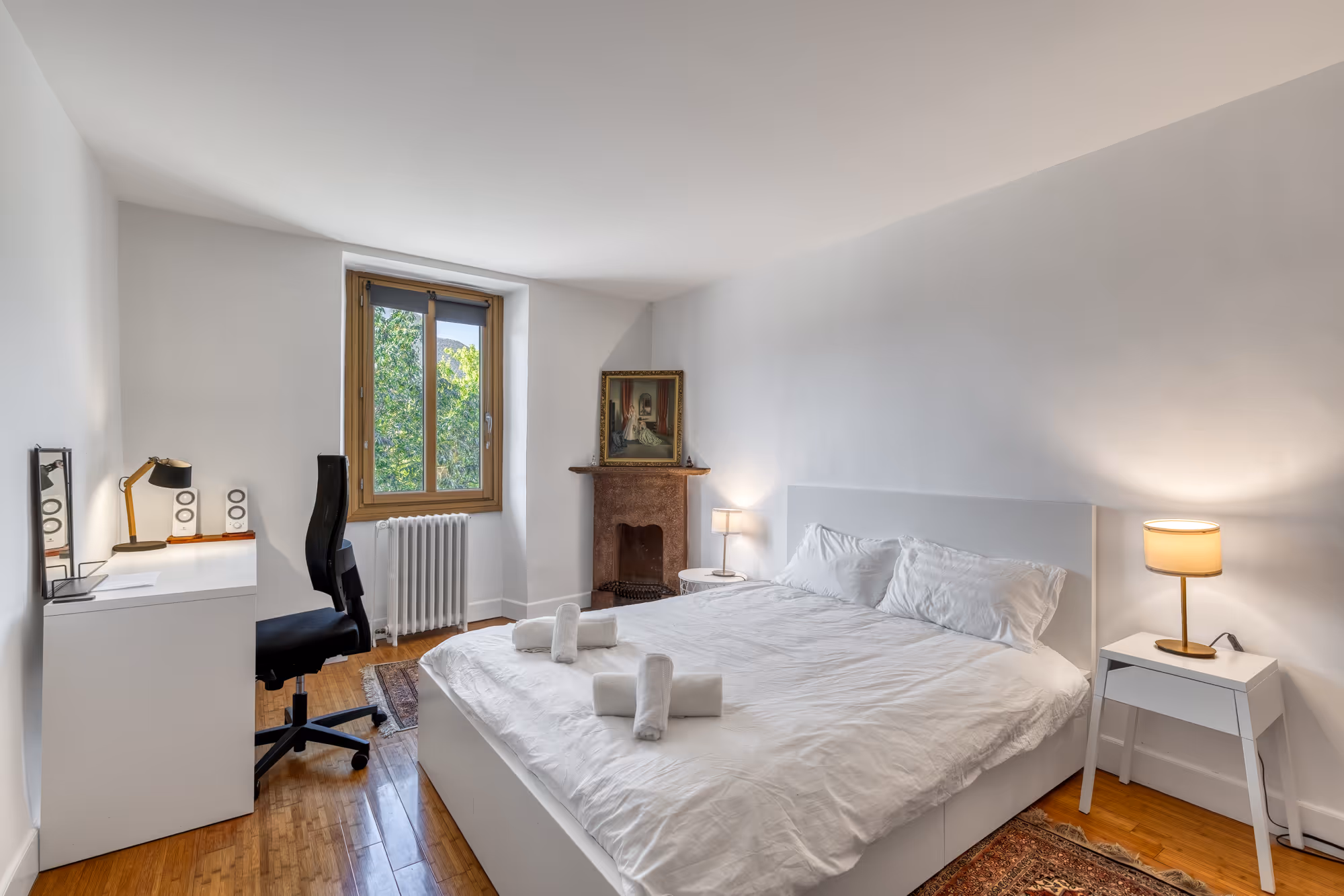 Salle de séjour moderne avec mur doré, un canapé-lit, fauteuil, table basse et chambre visible à travers un trou rond.