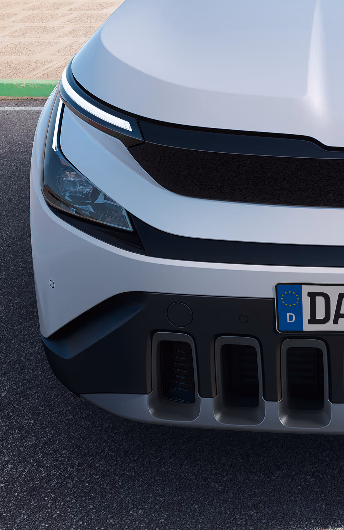 Eine Nahaufnahme der Frontpartie des Škoda Enyaq in der Farbe Olibo-Grün Metallic. Im Fokus steht der beleuchtete, markante Kühlergrill, der zusammen mit den Voll-LED-Matrix-Scheinwerfern das moderne und selbstbewusste Design unterstreicht. Unten rechts steht auf einer dunkelgrün abgesetzten Fläche der Schriftzug „Sicherheit und Assistenten“.