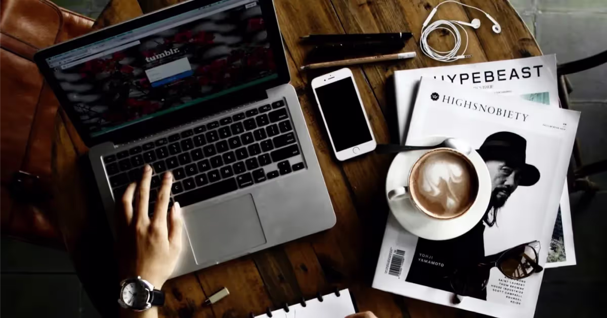 Hand Lettering in a notebook on a table beside a laptop and coffee cup