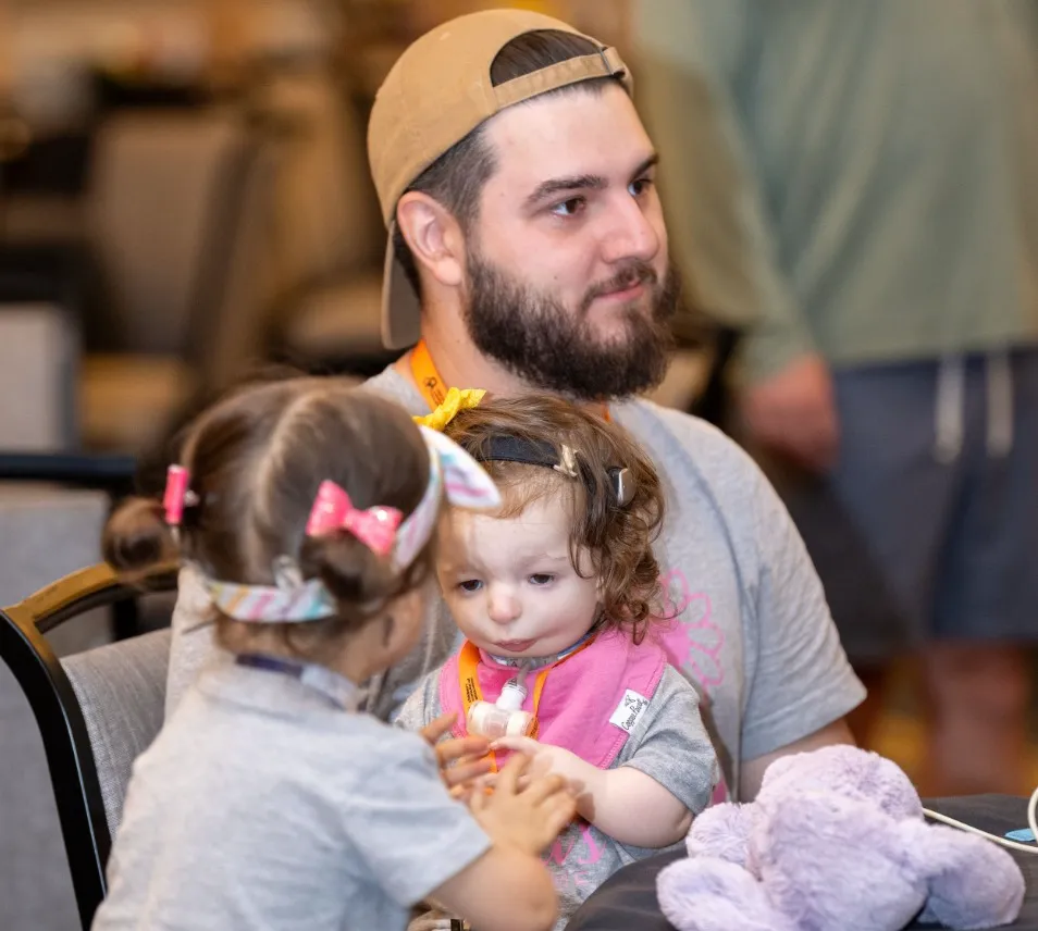 A father holds his child at the Annual Retreat