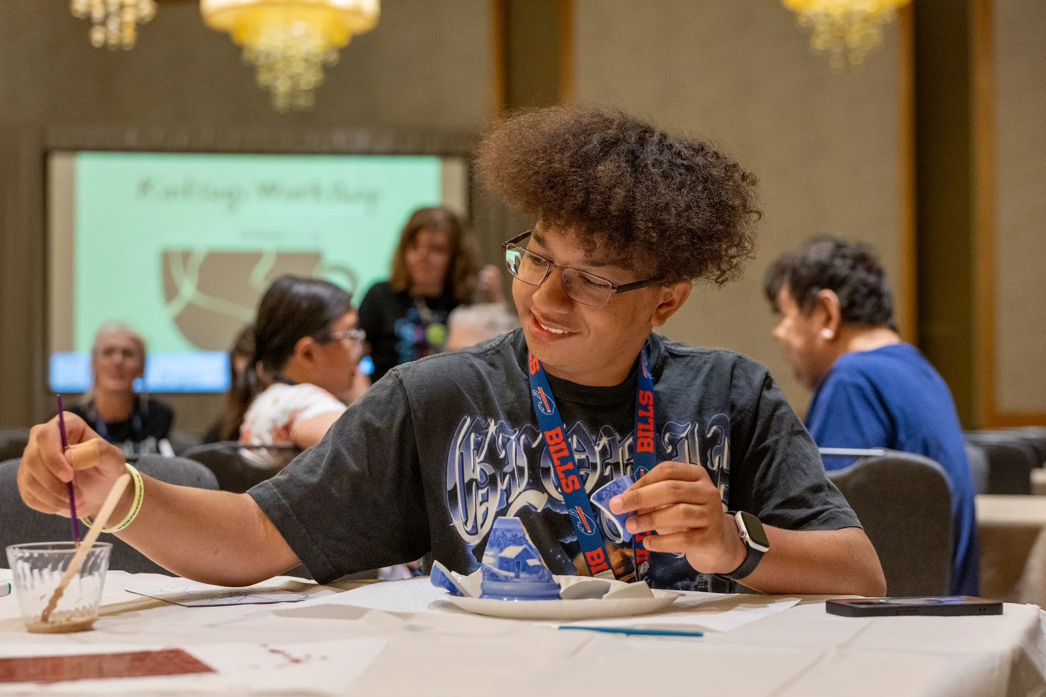 A CCA volunteer helps children with a craft activity at a family retreat