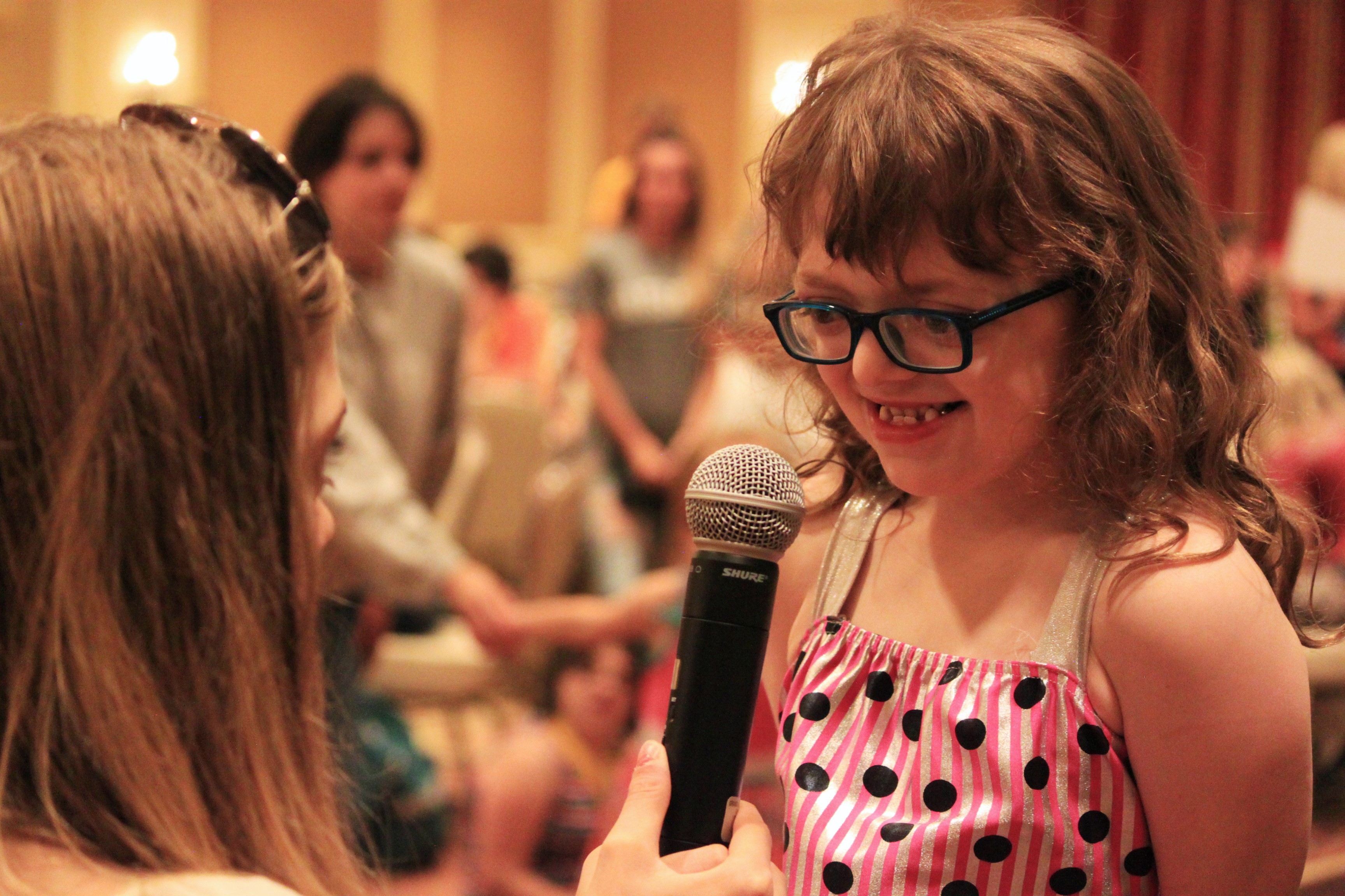 A girl speaking into a microphone.