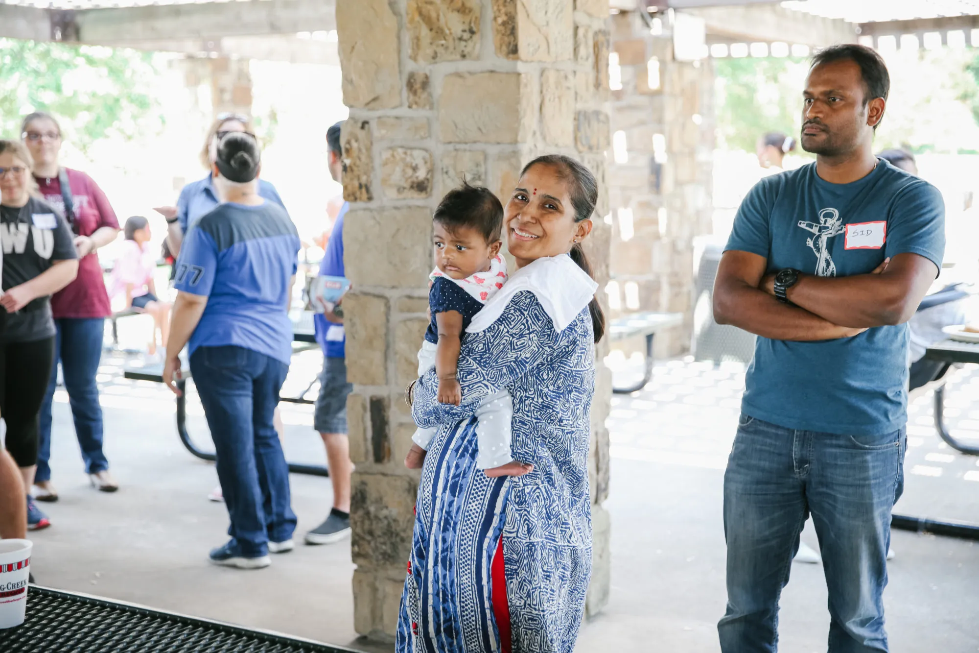 Attendees gather near a stone pavilion at a CAM event
