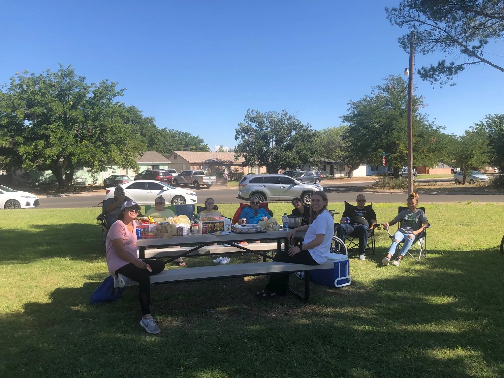 A family group sits together at an outdoor picnic table