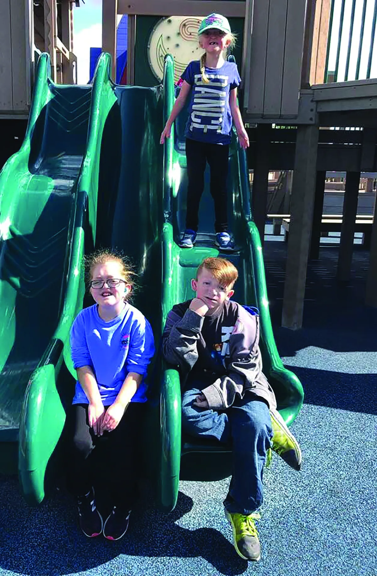Children pose together on a playground slide