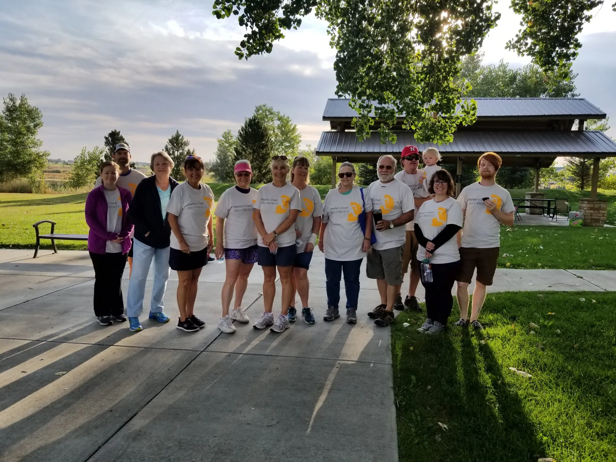 A group poses together outdoors near a park pathway