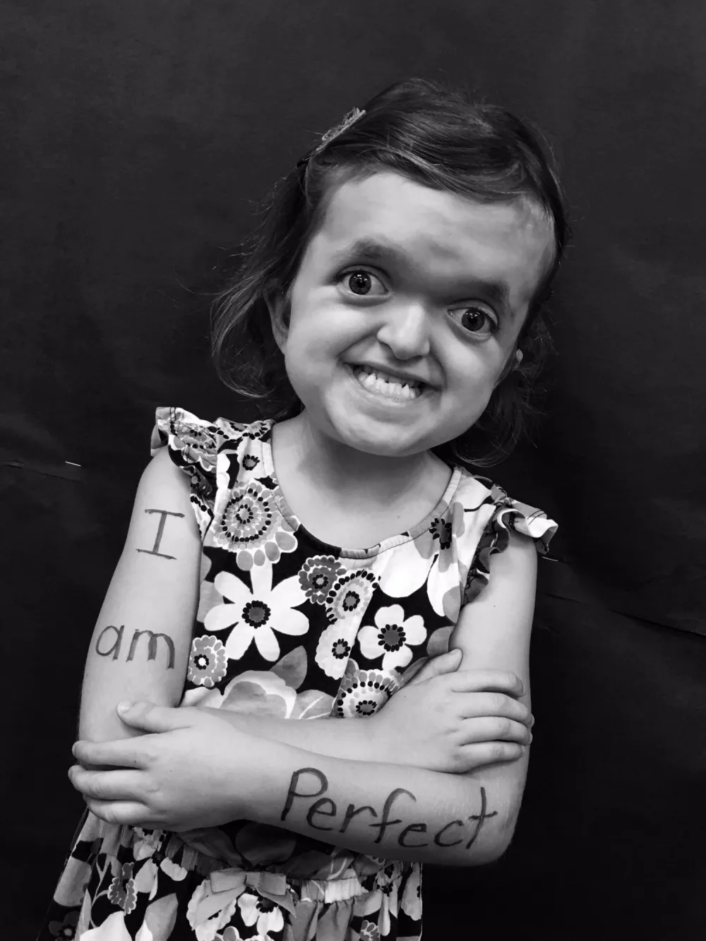 Black and white portrait of a child holding flowers