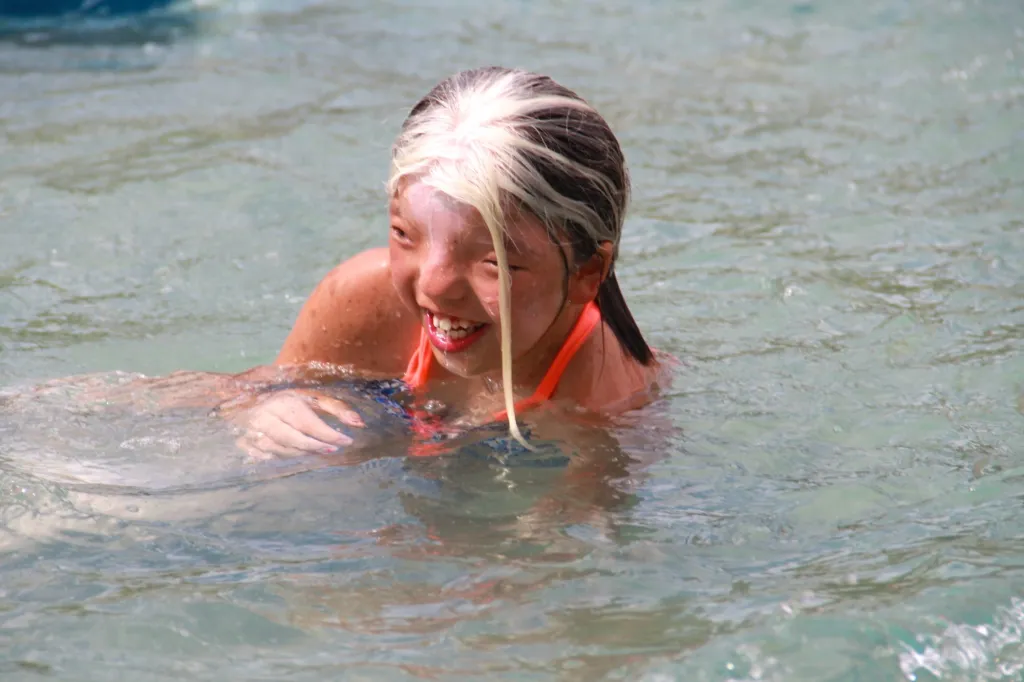 A child plays in the water at a pool event
