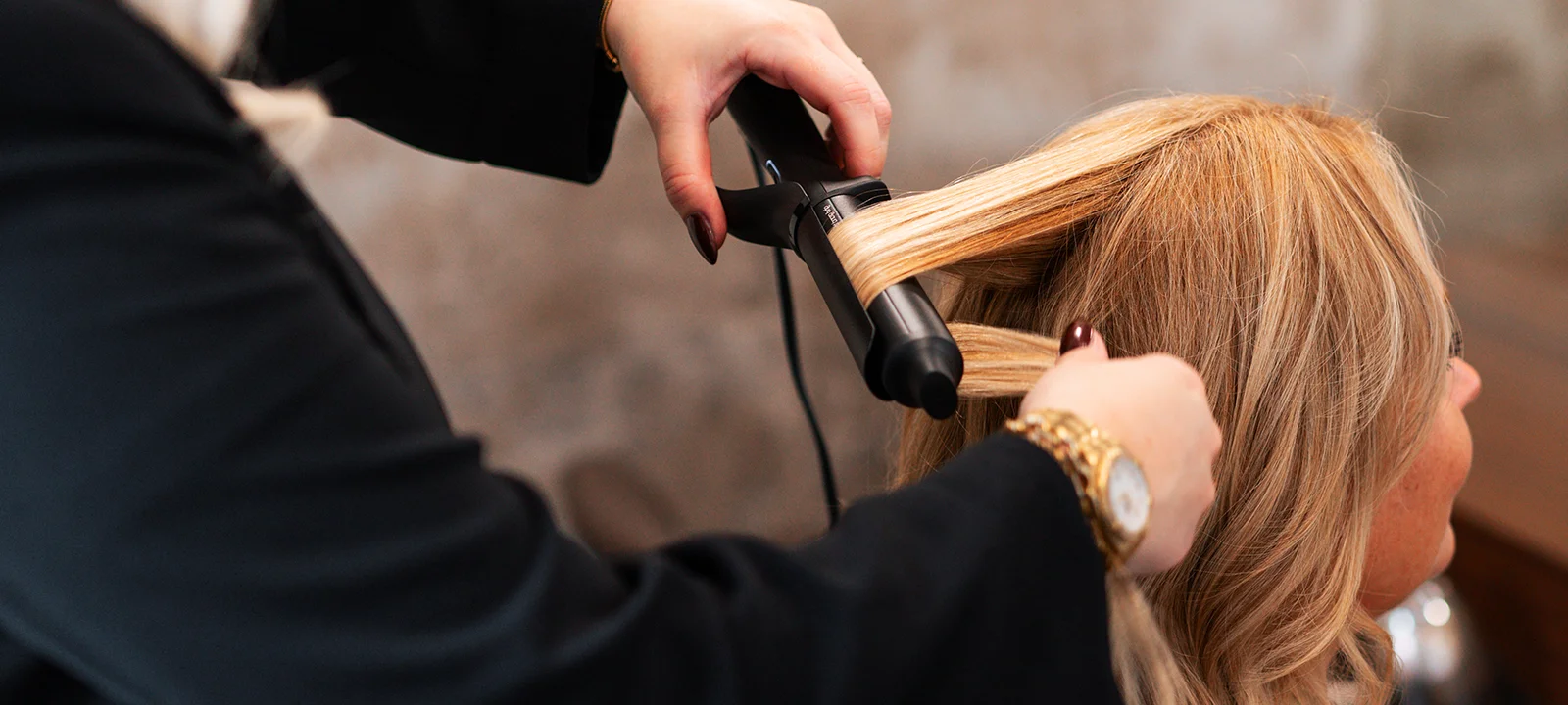 Een vrouw krijgt krullen in haar haar.