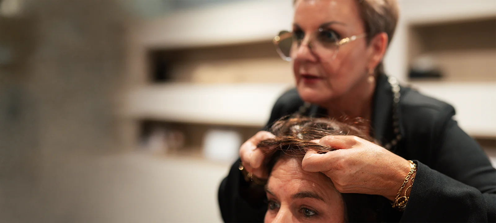 Kapster onderzoekt het haar van een klant nauwkeurig in een kapsalon.