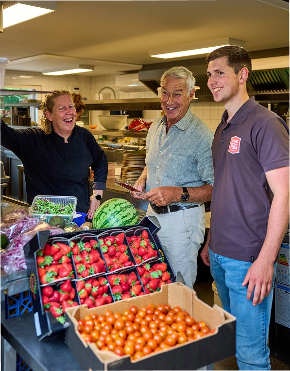 Chef en medewerkers van Heerkens Vers bekijken aardbeien en watermeloen in een restaurantkeuken