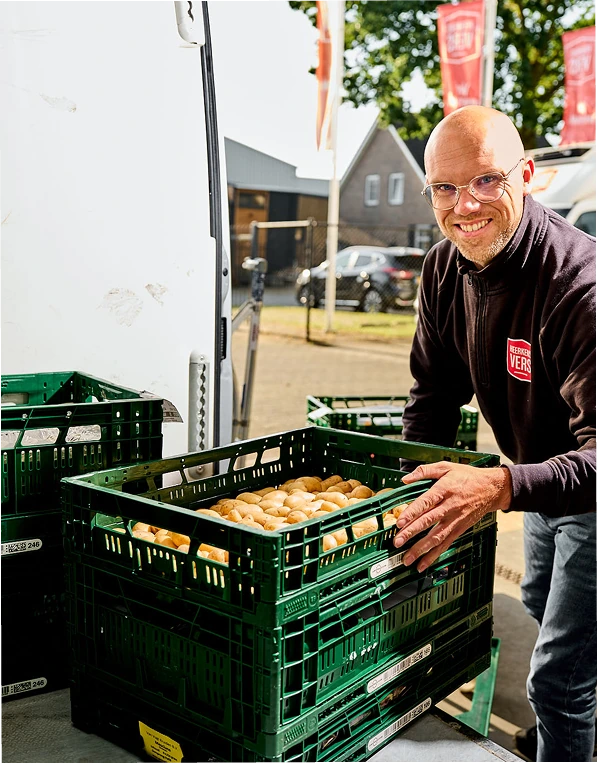 Chauffeur van Heerkens Vers lost een krat met verse producten
