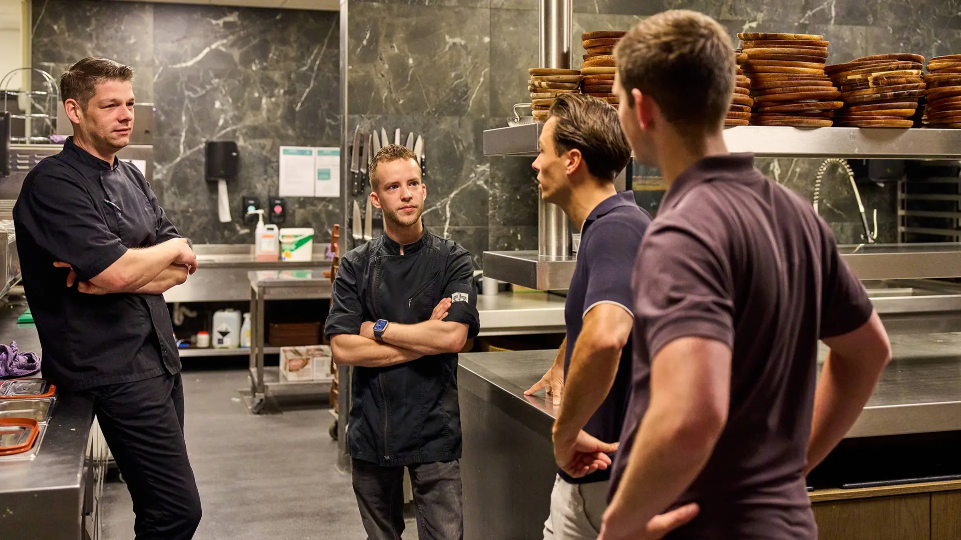 Chefs in gesprek met medewerkers van Heerkens Vers in een professionele keuken
