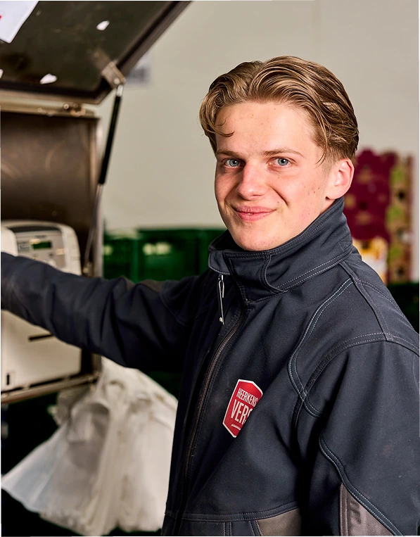 Jonge medewerker van Heerkens Vers kijkt lachend in de camera