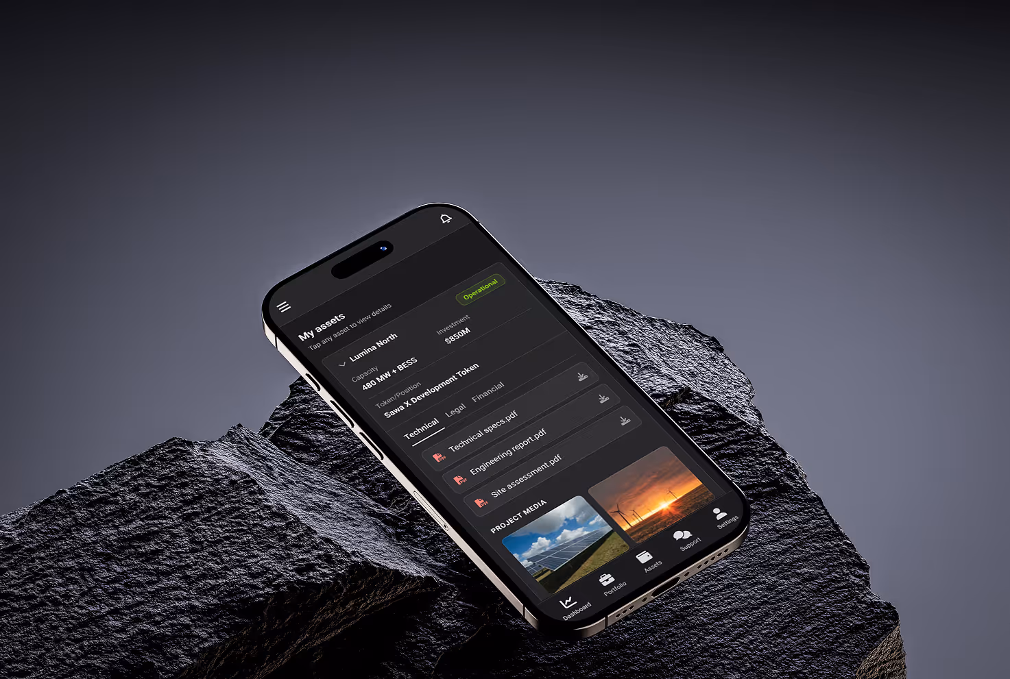 Smartphone displaying financial dashboard with capital committed of $525.0k and yield distributed of $18.2k, placed on a dark textured rock surface.