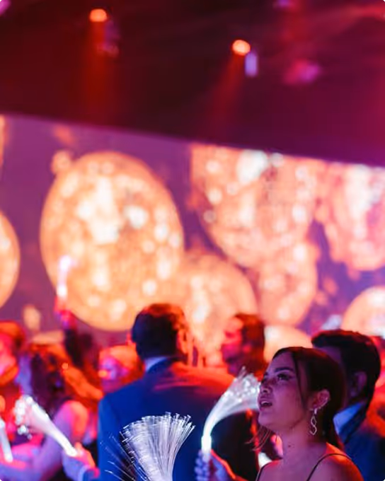 Gens à une fête avec éclairage coloré et décorations lumineuses en arrière-plan.