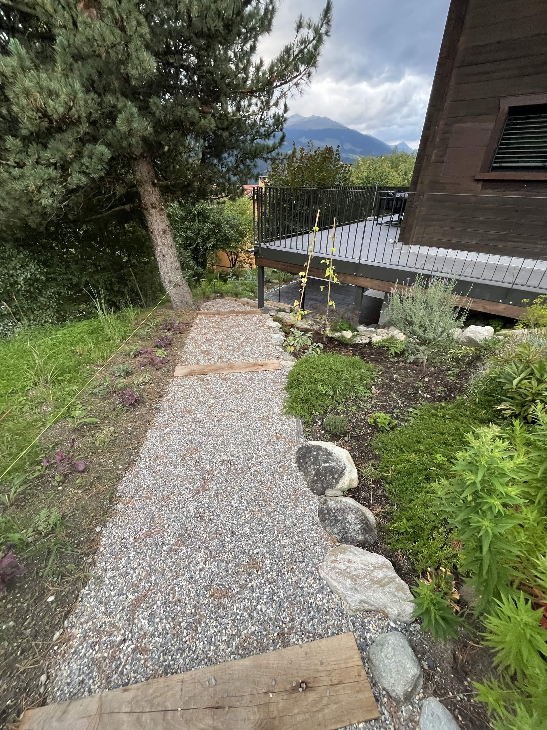 Kiesweg mit Holztritten und Bepflanzungen