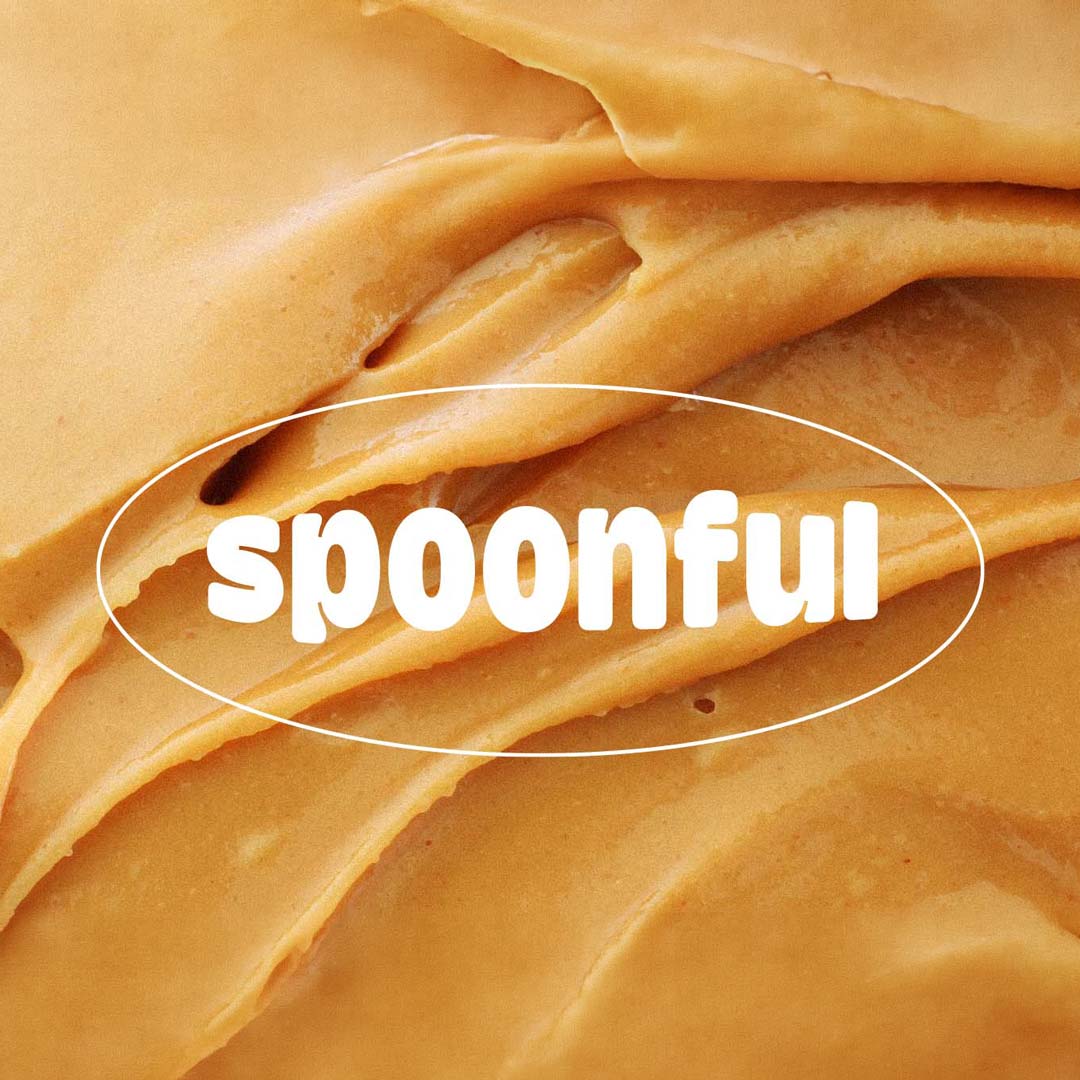 Close-up of creamy peanut butter with the word spoonful in white text overlayed.