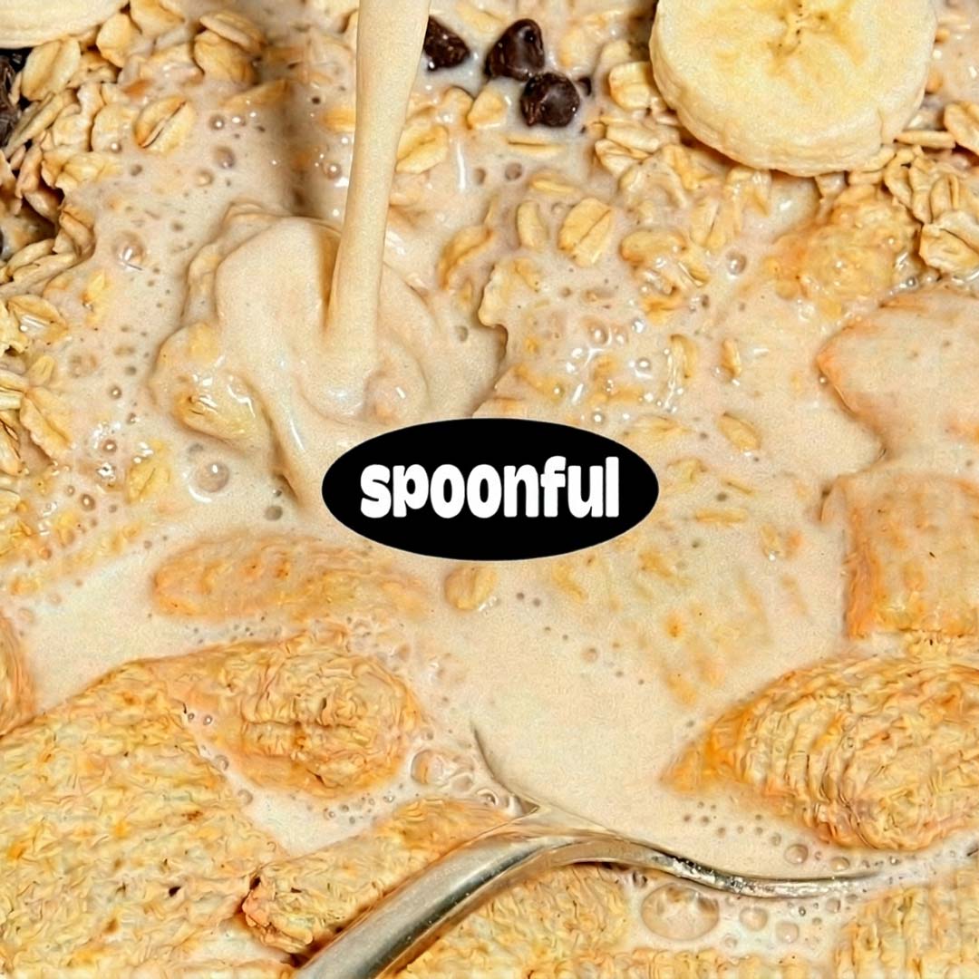 Milk pouring over cereal with oats, banana slices, and chocolate chips in a bowl with spoon.