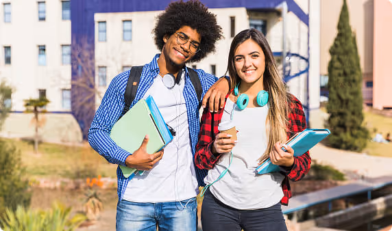 Dois alunos sorridentes no pátio da faculdade.