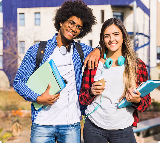 Alunos sorrindo no pátio da faculdade, usando roupas casuais, segurando livros e fones de ouvido.