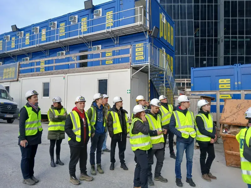Skupina studentů na staveništi během odborné exkurze.