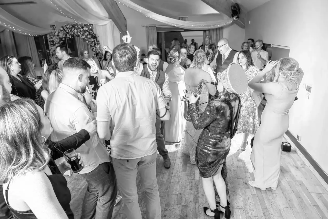 cat from saxophonique at a wedding with hands in the air black and white