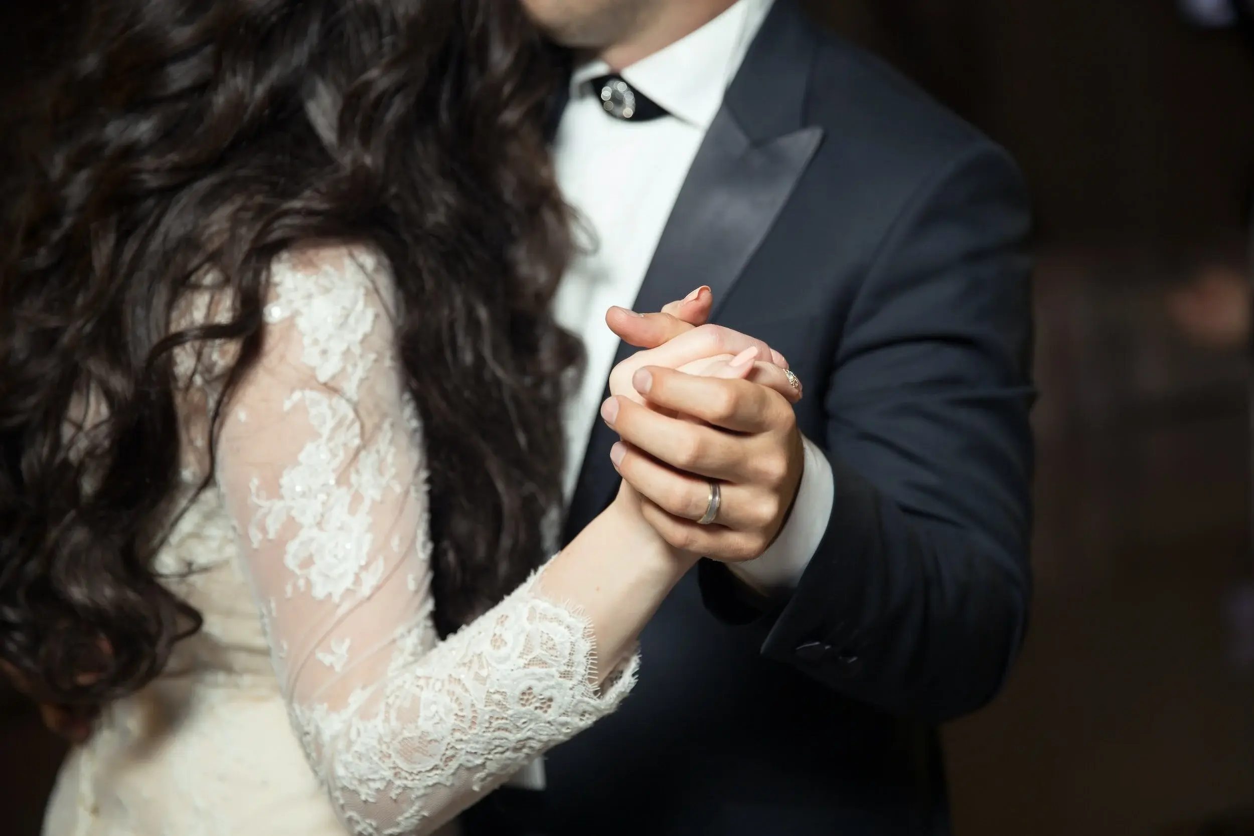 bride and groom holding hands at a wedding during their first dance