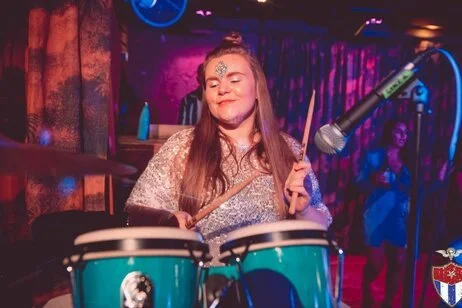 grace playing percussion bongos and drumsticks