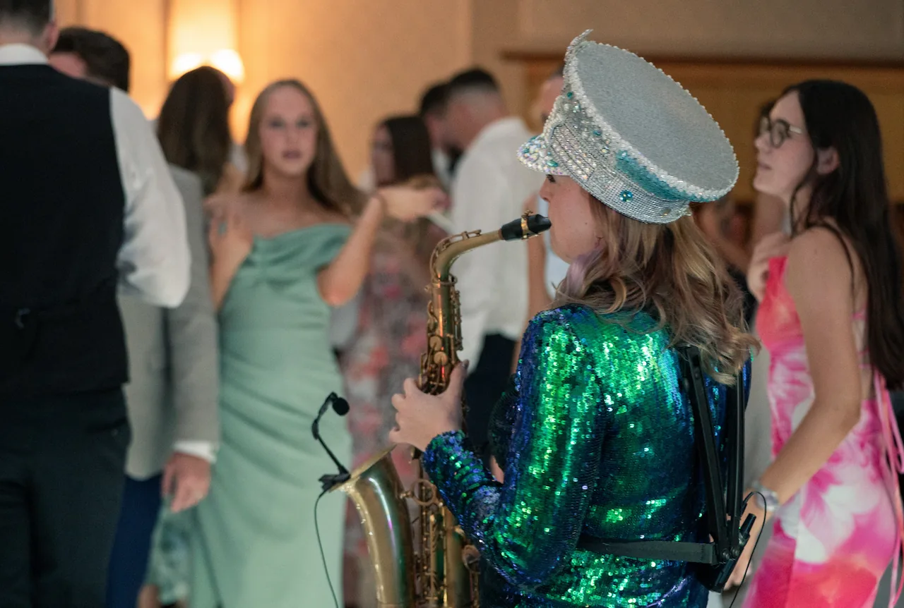 Cat at the last drop village hotel playing a saxophone at a wedding