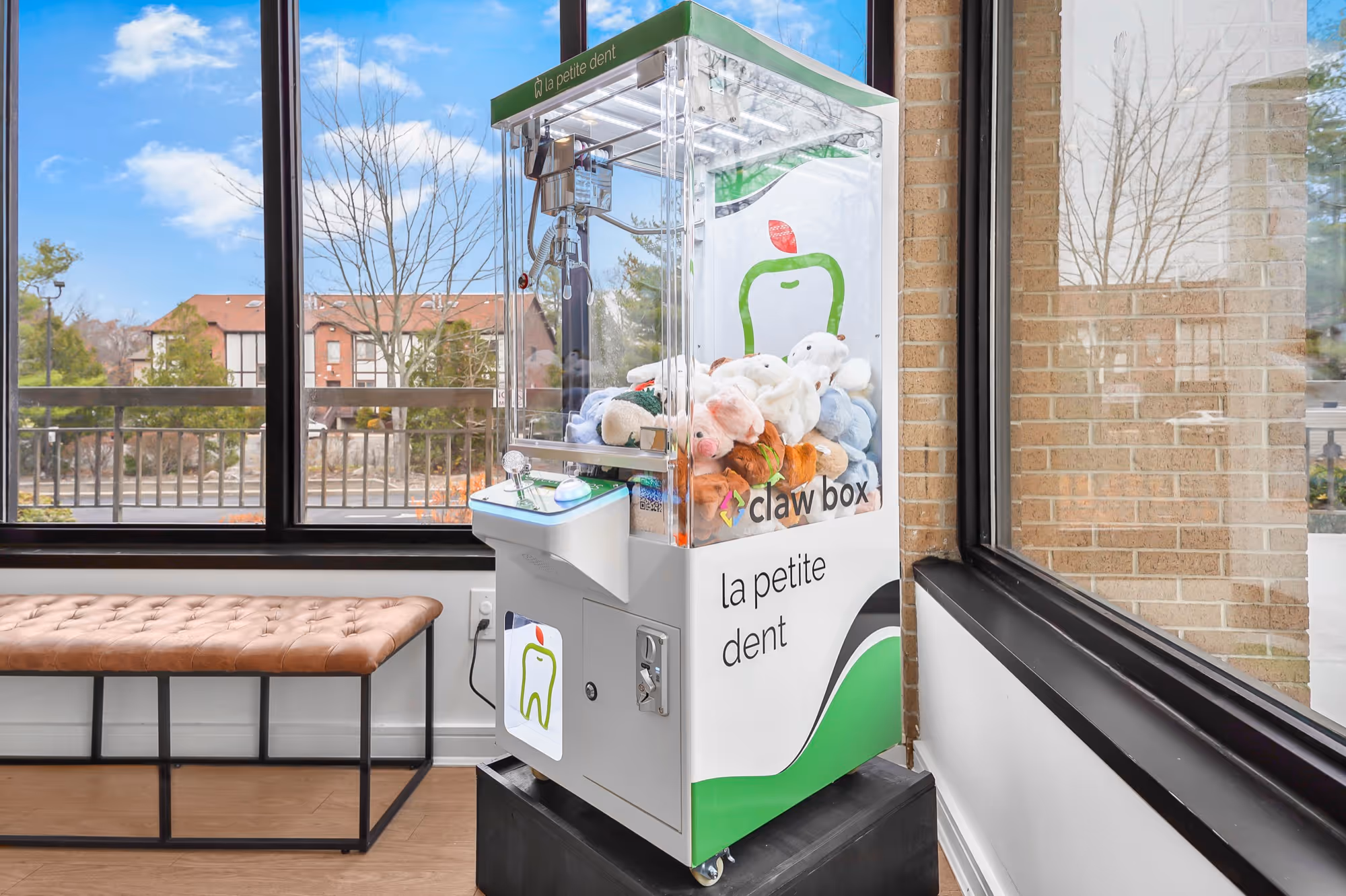Mini claw box machine in the La Petite Dent pediatric dental waiting room with custom co-branded wrap