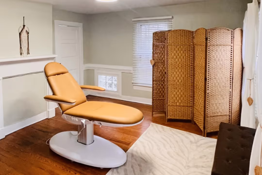 Modern beige reclining chair in a room with hardwood floor and woven privacy screen.