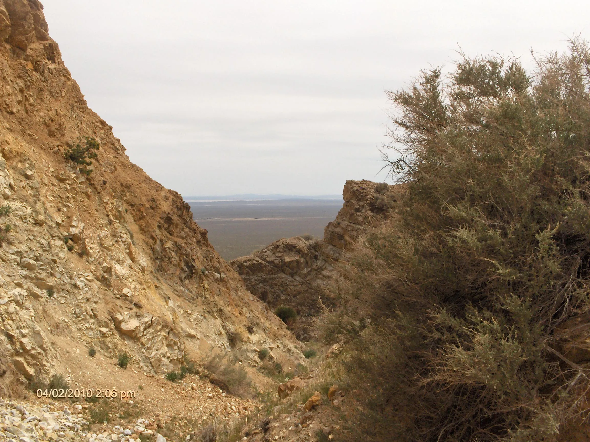 Looking through a narrow desert crevice toward a wider landscape beyond, symbolizing the transition from uncertainty to opportunity.