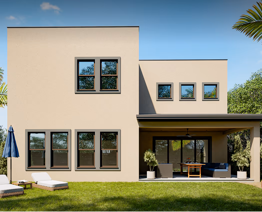 Modern two-story beige house with multiple windows, a covered patio with seating and a table, and green lawn with lounge chairs and umbrella.