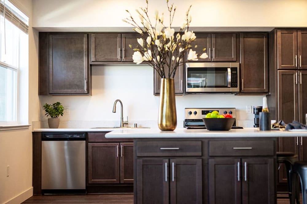 Kitchen with island, brown cabinets and stainless steel appliances
