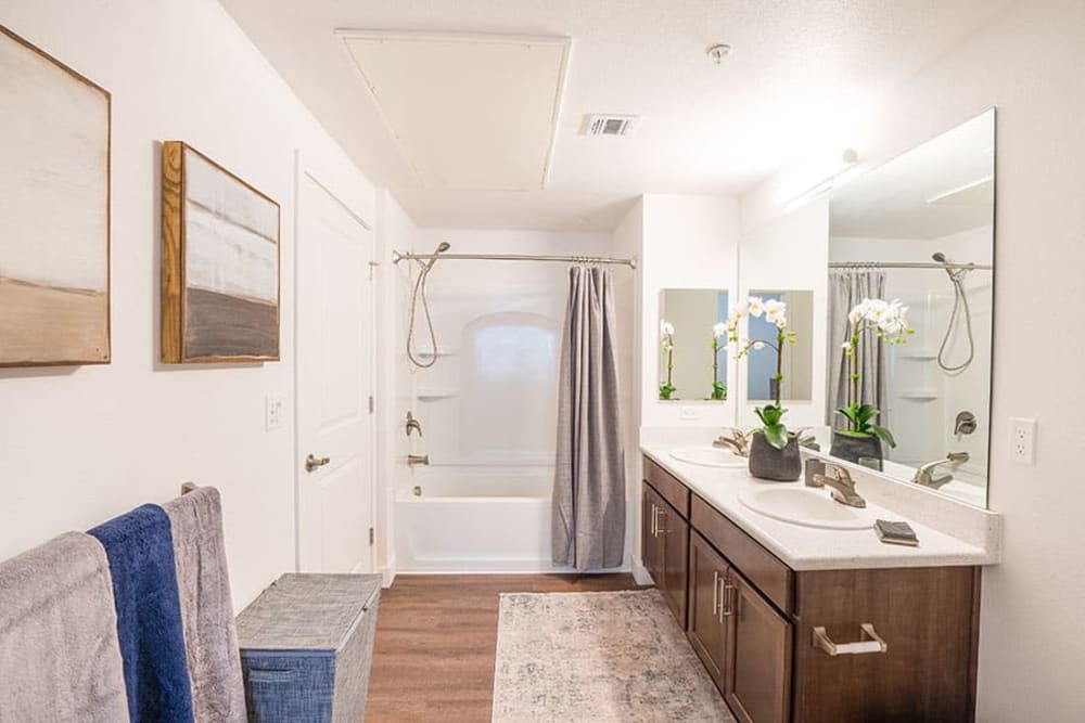 Bathroom with shower tub combo, and vanity with brown cabinets