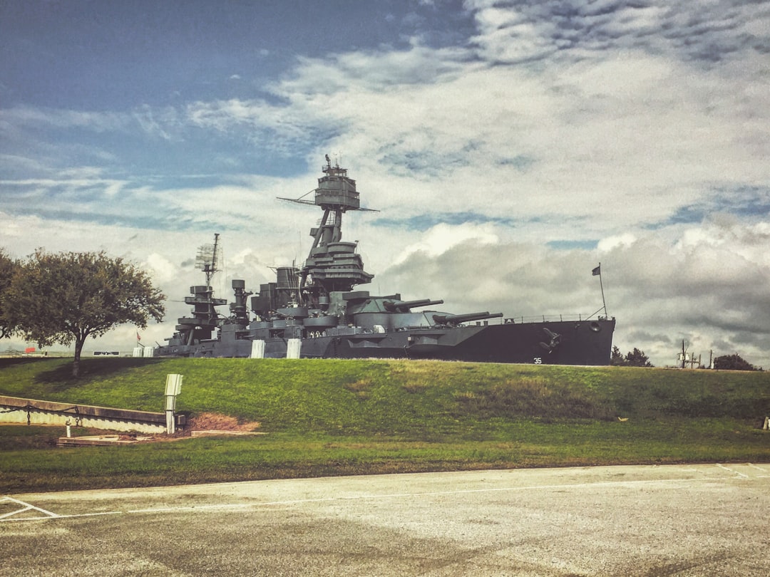 a large battleship sitting on top of a lush green field