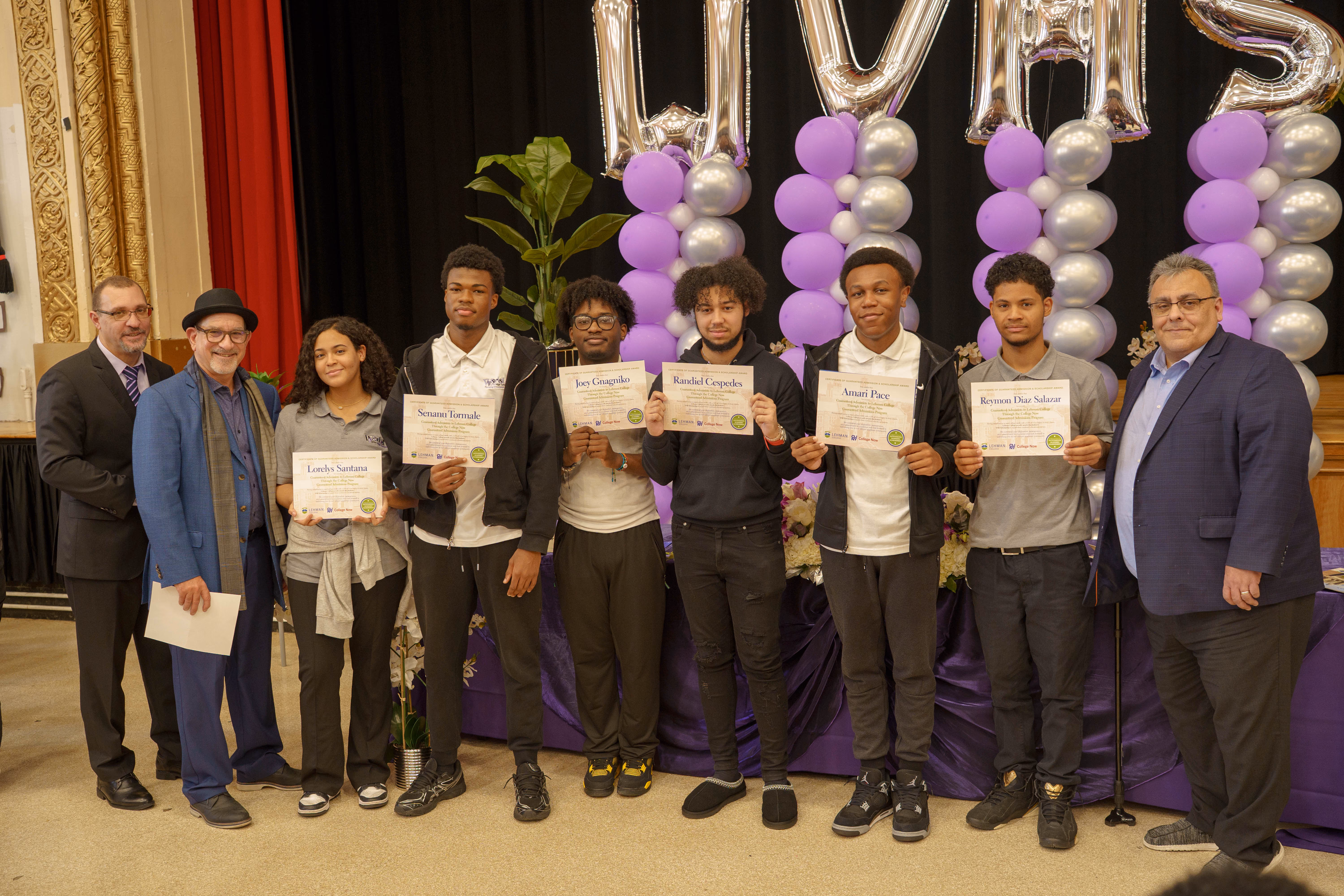 Students and staff holding achievement certificates at a school awards ceremony