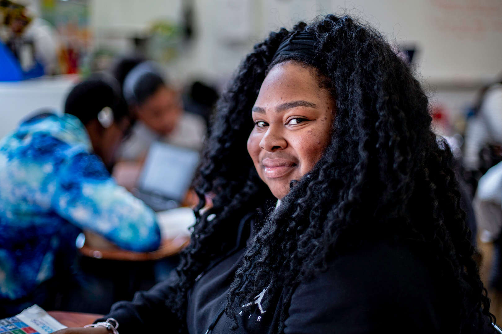 Student smiling in a busy classroom setting