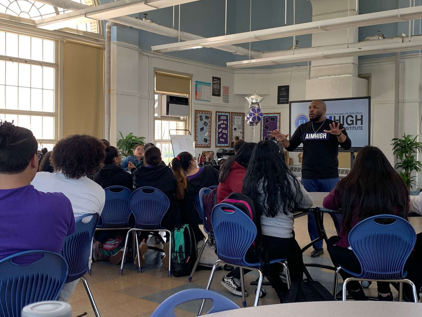 AimHigh Institute presenter speaking to seated students in a classroom