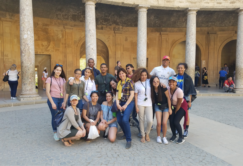Students posing together at a historic columned courtyard on field trip