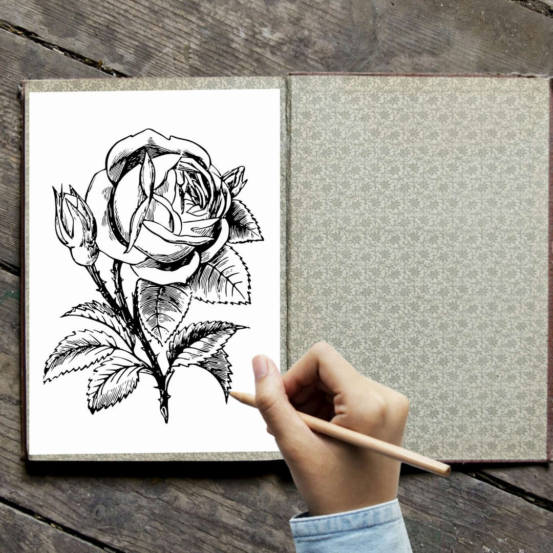 Student hand drawing a detailed rose sketch in a sketchbook