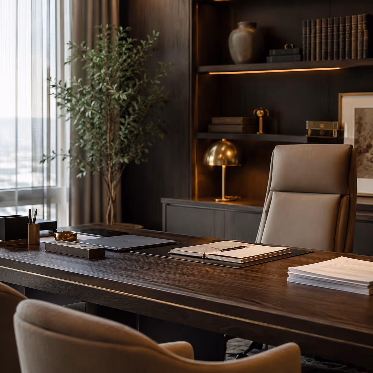 Modern office with dark wooden desk, leather chair, open notebook, stack of papers, and indoor plant near window.