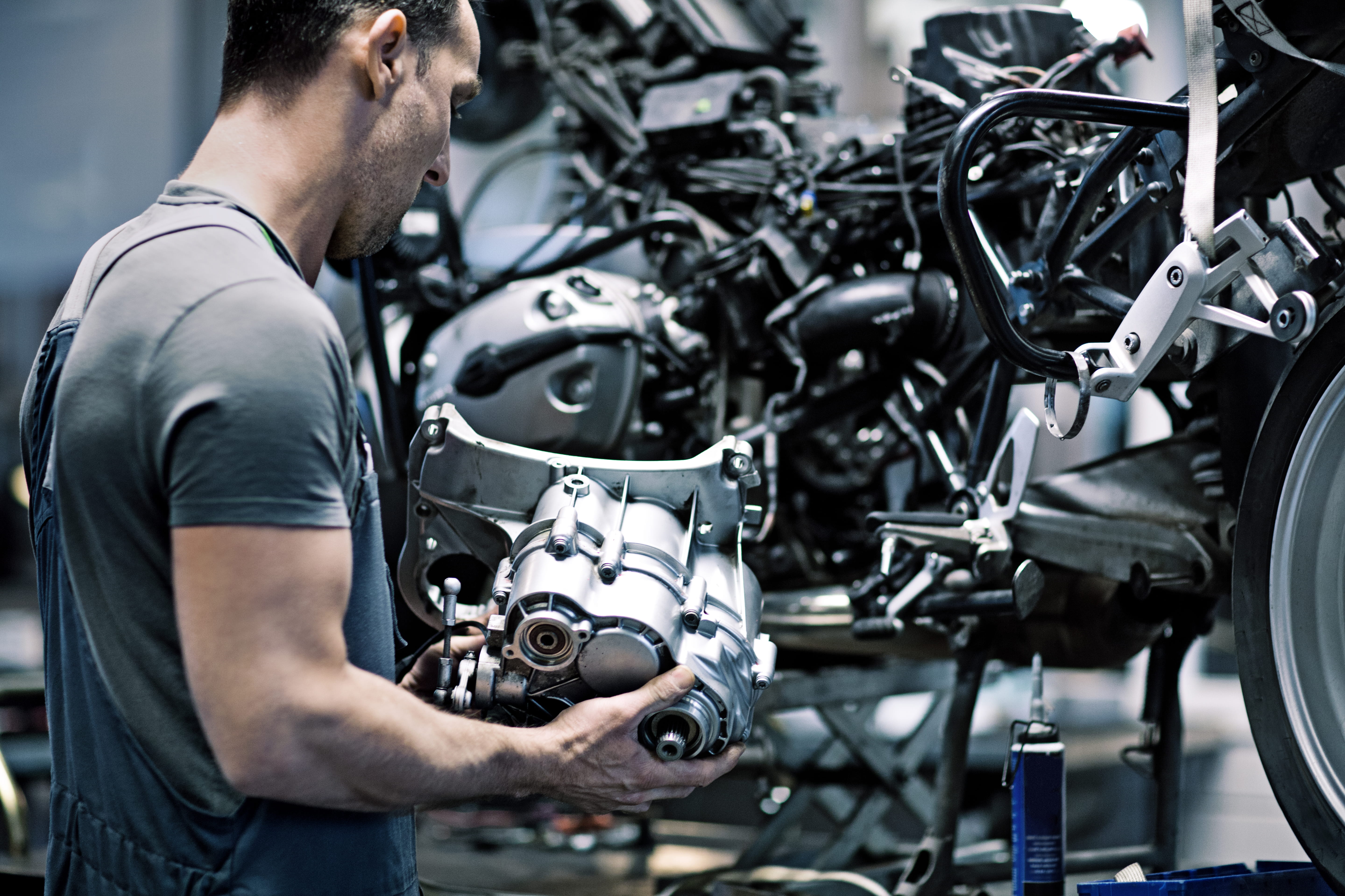 Motorcycle mechanic working on motorbike in a workshop.
