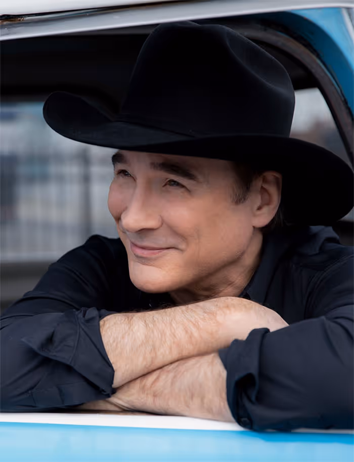Portrait of Clint Black wearing a black cowboy hat.