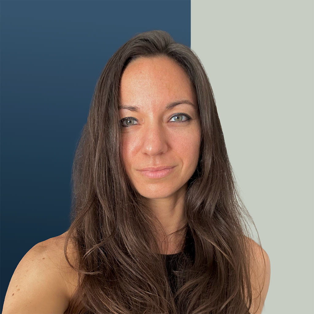Woman with long brown hair and green eyes against a blue and light gray background.