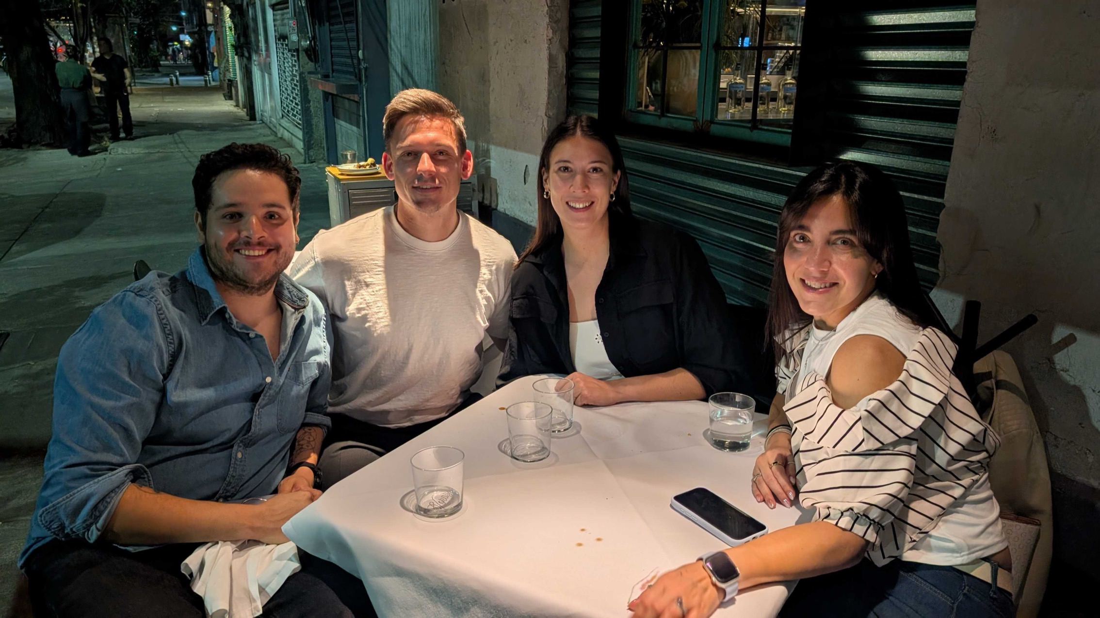 Four members of the Goodword team at an outdoor table in the evening