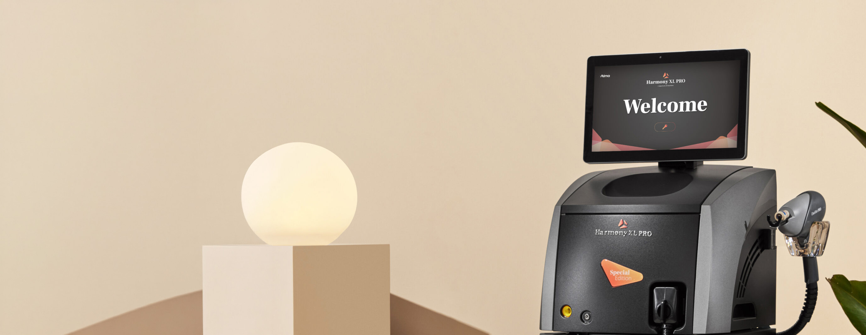 Harmony XL PRO medical device with a screen displaying 'Welcome' next to a glowing orb on a pedestal.