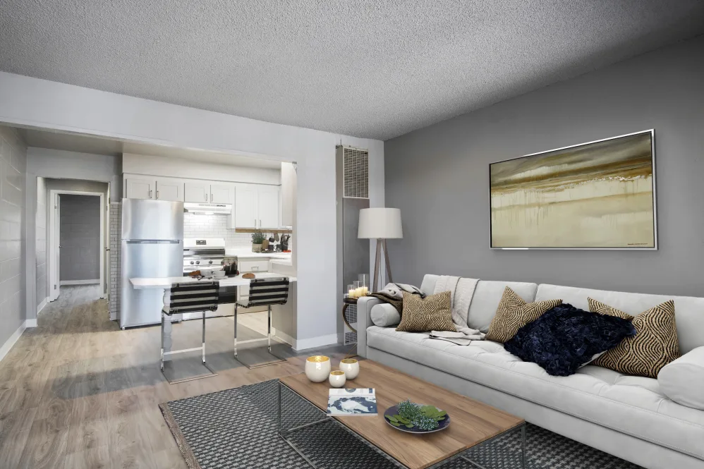 Virtually furnished living area with sofa, coffee table and view of kitchen