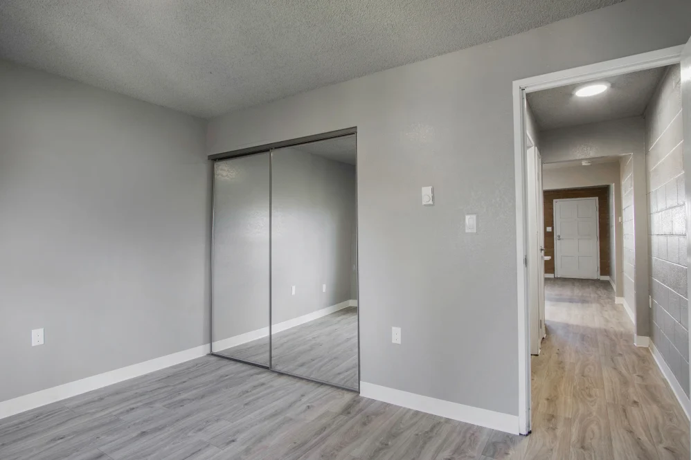 Unfurnished bedroom with wood floors and mirrored closet doors